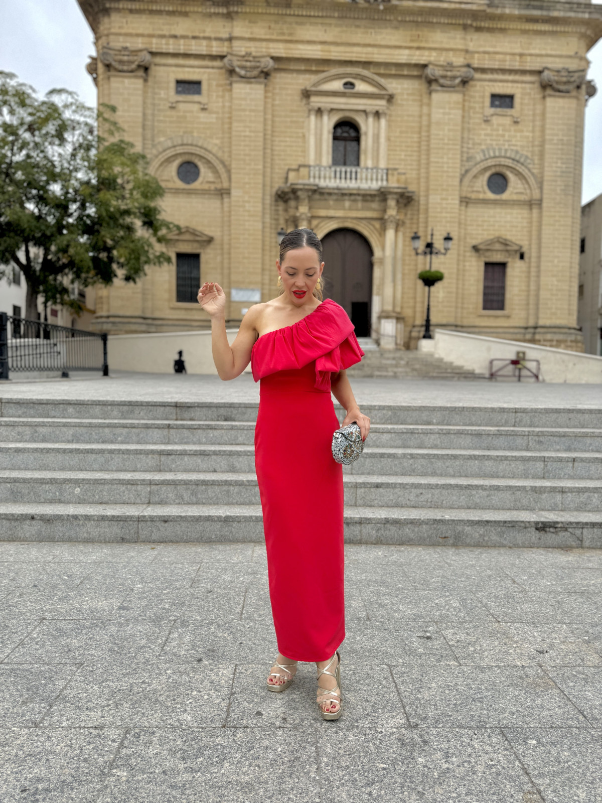 Vestido de fiesta midi en color rojo con corte asimétrico y volantes.