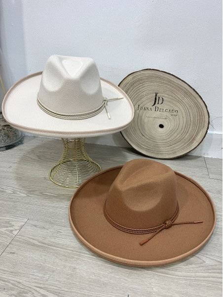 Sombrero de fieltro tipo fedora con ala ancha, adornado con tira.