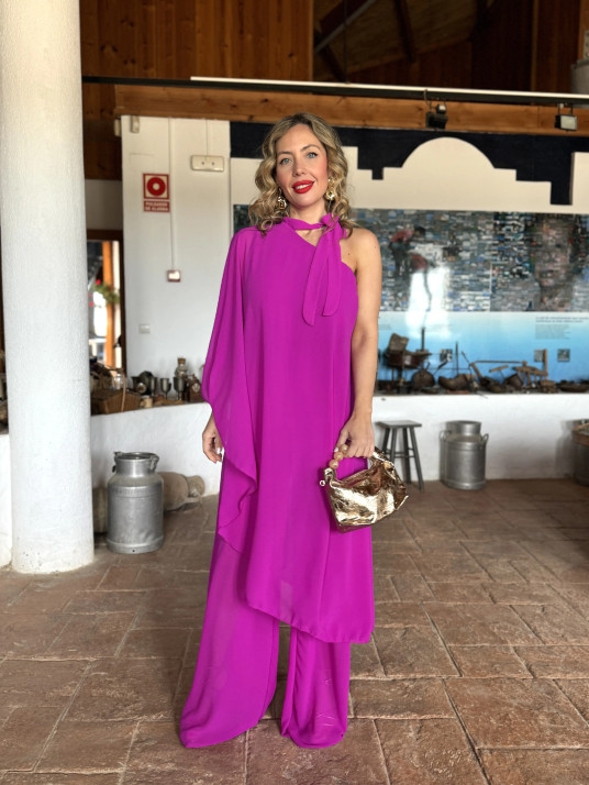 Mono de fiesta con capa de gasa asimétrica en color buganvilla.