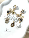 Pendientes dorados con piedras brillantes y nacaradas.