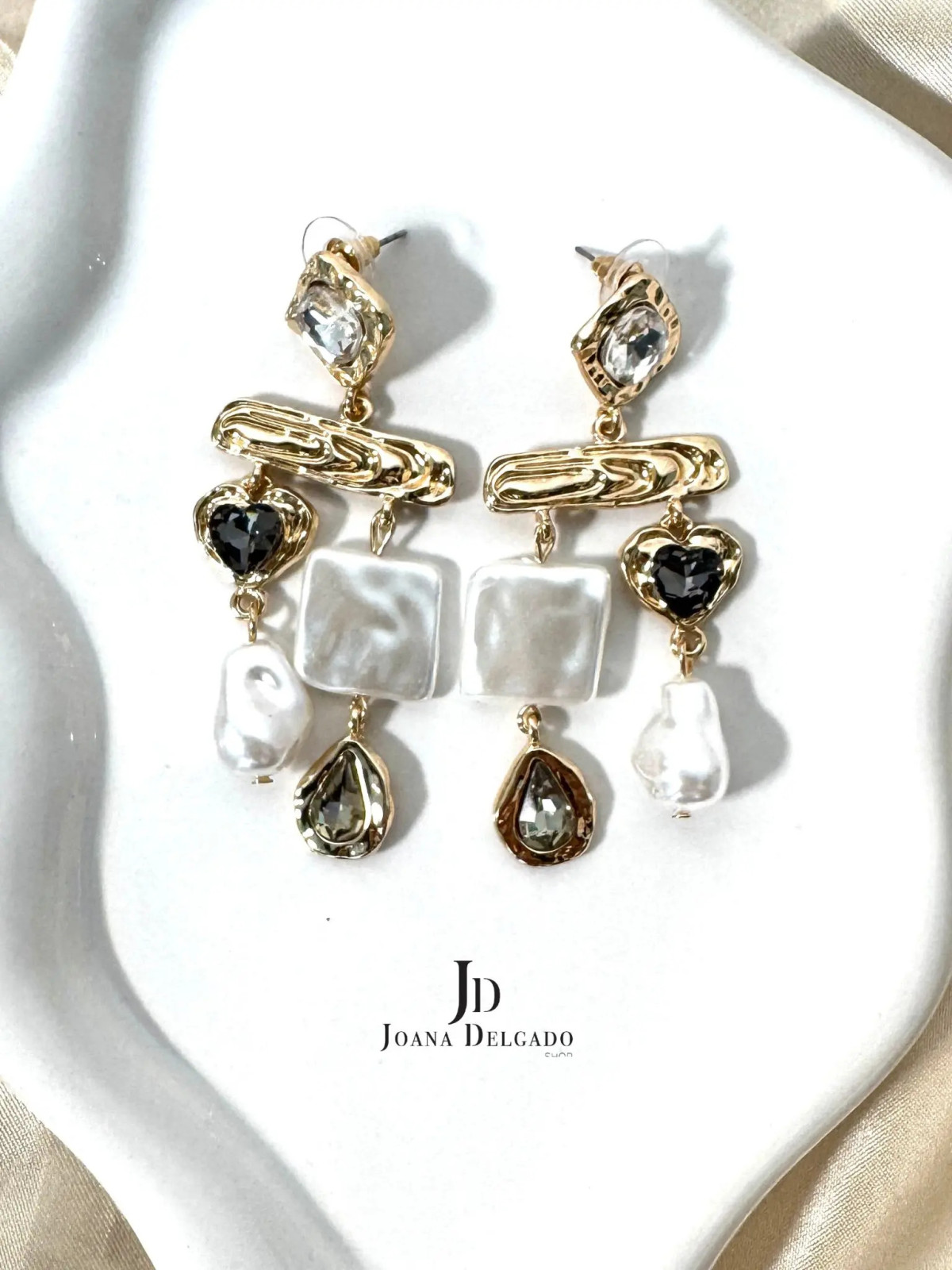 Pendientes dorados con piedras brillantes y nacaradas.