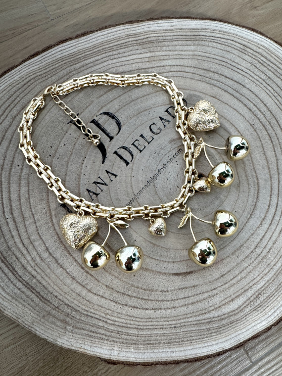 Collar metálico dorado con adornos en forma de cerezas y corazones.