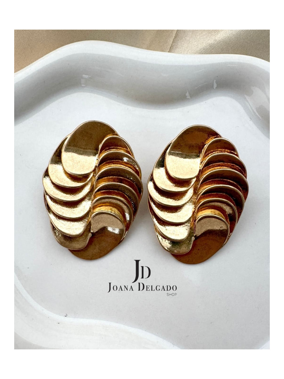 Pendiente dorado ovalado con relieve, ideal para complementar tus look