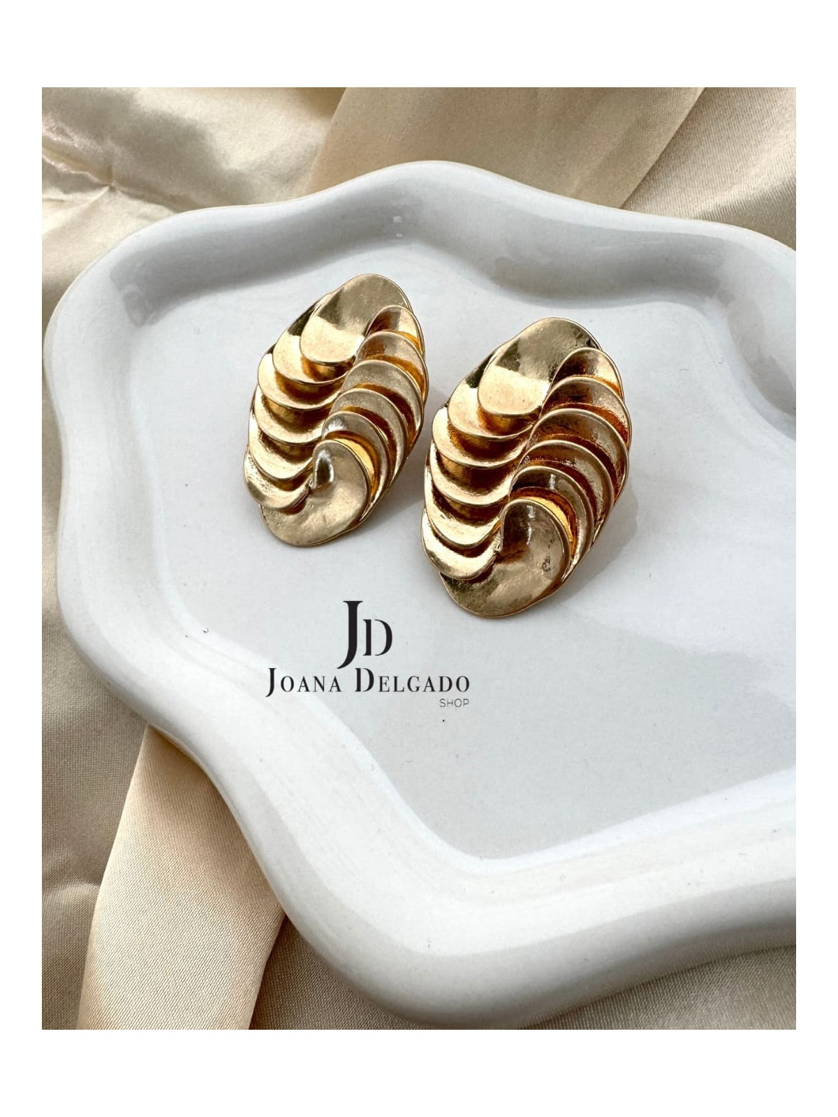 Pendiente dorado ovalado con relieve, ideal para complementar tus look