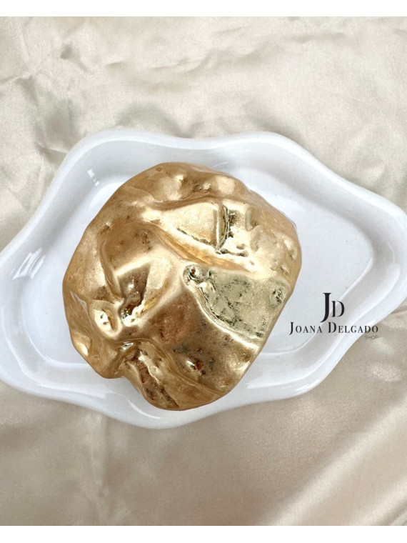 Brazalete metálico dorado con relieve.