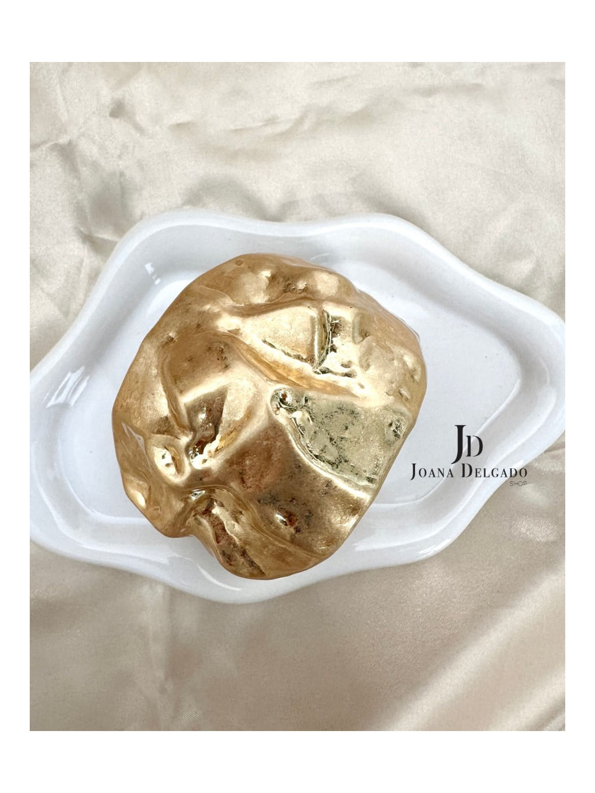 Brazalete metálico dorado con relieve.