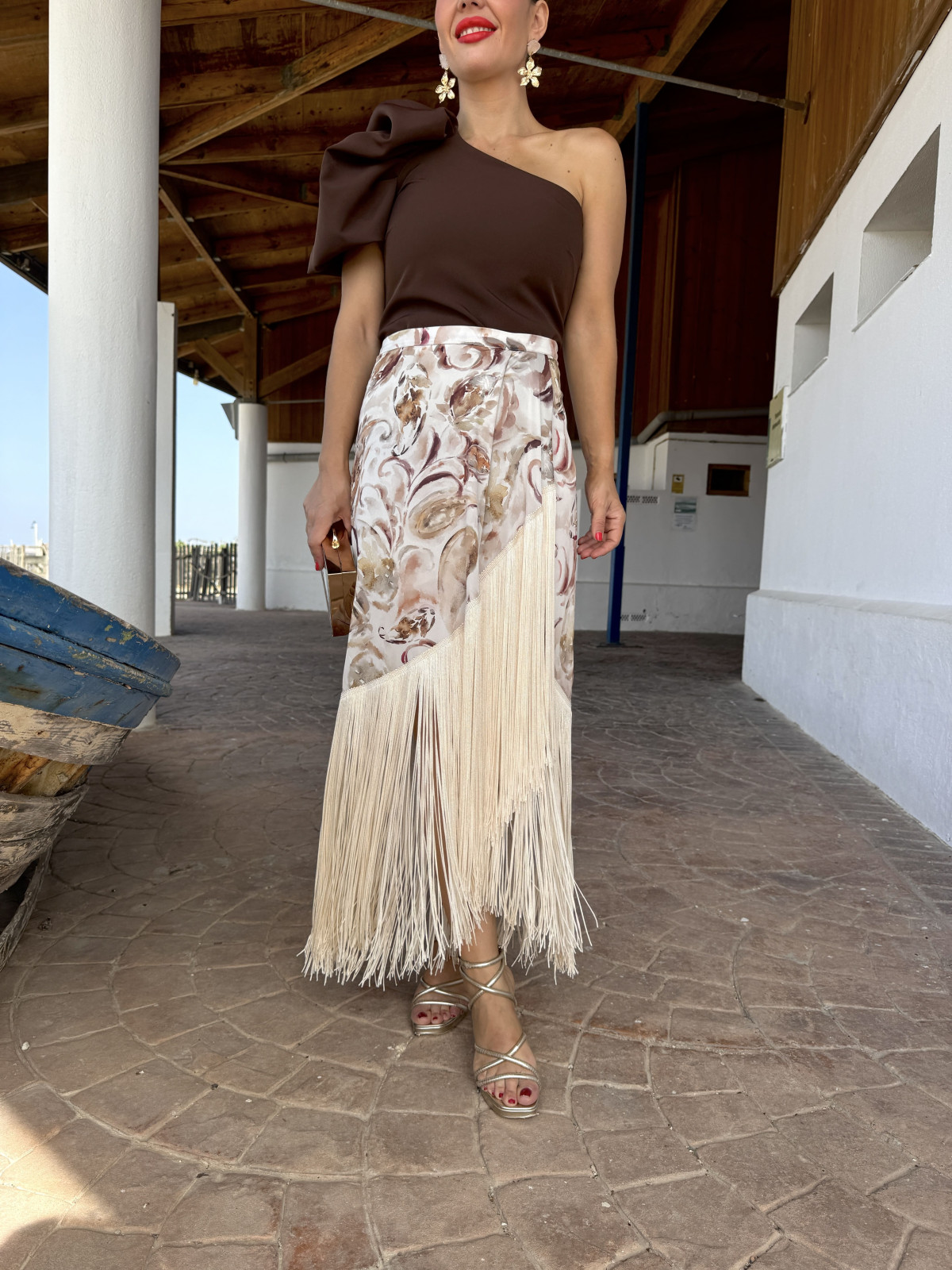 Falda de fiesta en tejido satinado estampado y adornada con flecos.