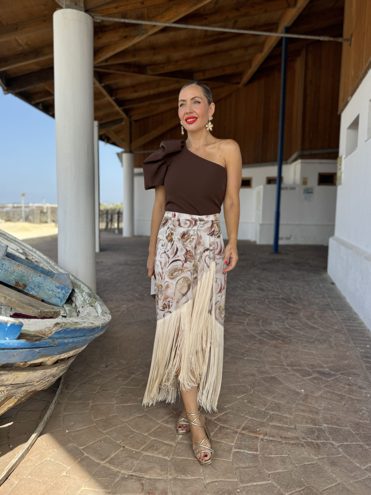 Falda de fiesta en tejido satinado estampado y adornada con flecos.