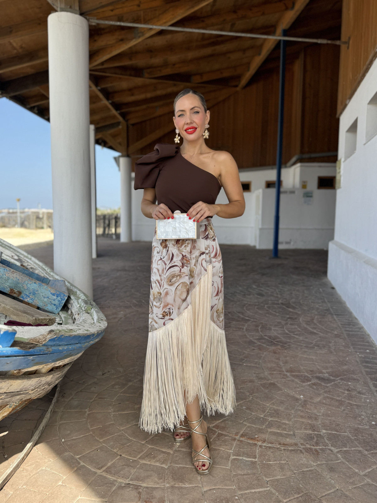 Falda de fiesta en tejido satinado estampado y adornada con flecos.