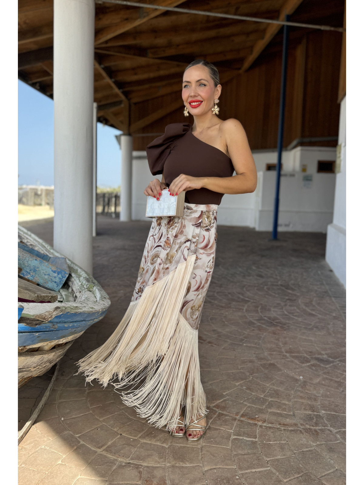 Falda de fiesta en tejido satinado estampado y adornada con flecos.