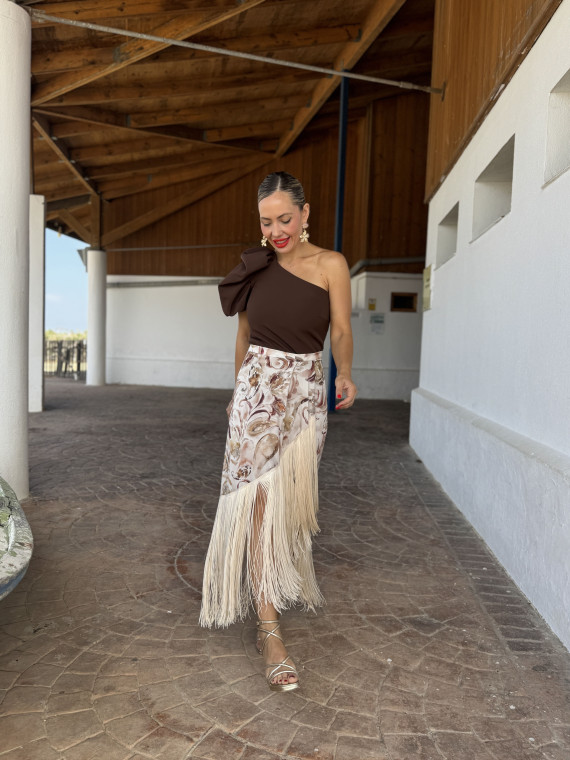 Falda de fiesta en tejido satinado estampado y adornada con flecos.