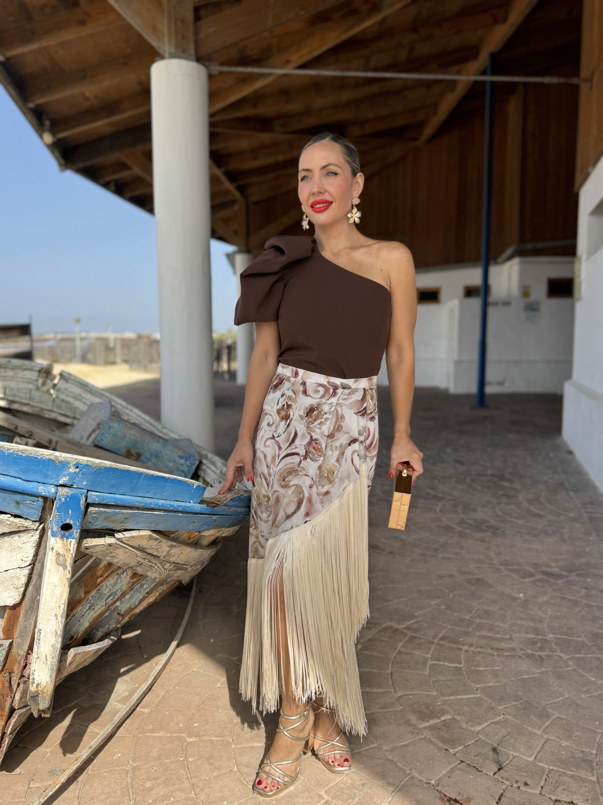 Falda de fiesta en tejido satinado estampado y adornada con flecos.