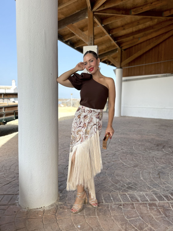 Falda de fiesta en tejido satinado estampado y adornada con flecos.