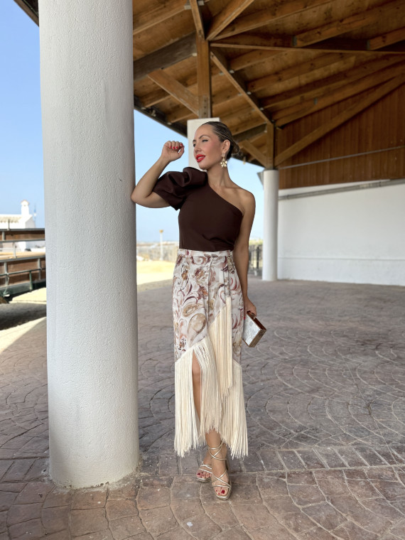 Falda de fiesta en tejido satinado estampado y adornada con flecos.