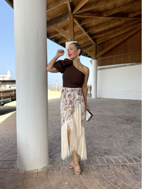 Falda de fiesta en tejido satinado estampado y adornada con flecos.