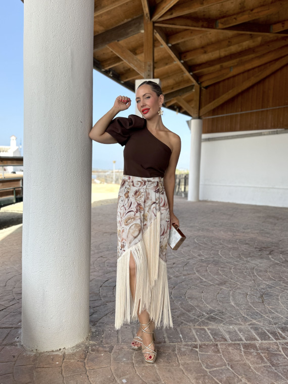 Falda de fiesta en tejido satinado estampado y adornada con flecos.