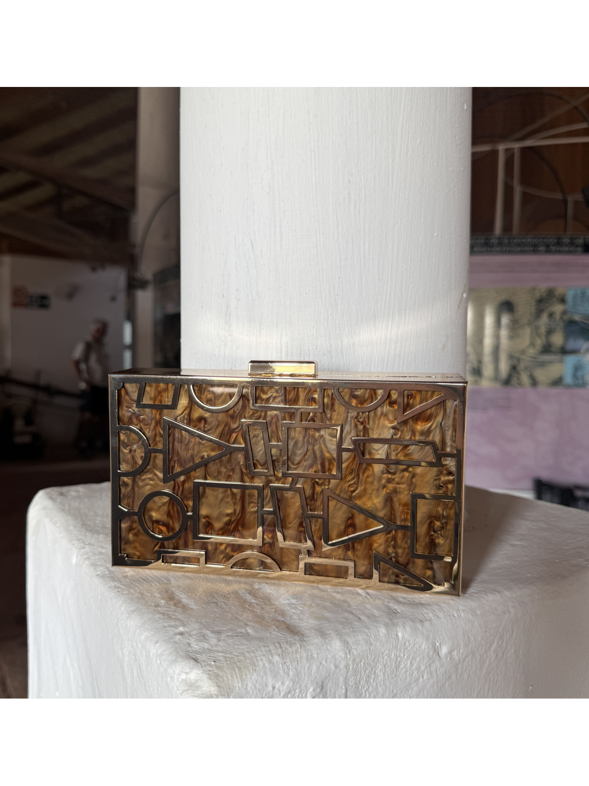 Bolso nacarado con montura en color dorado, en tonos color marrón.