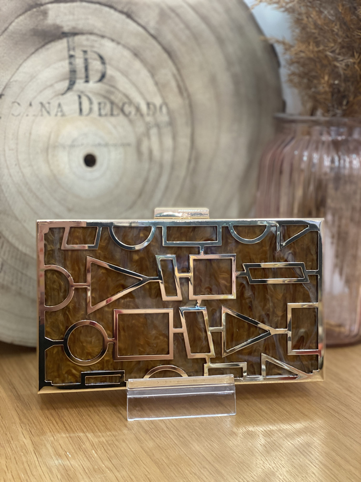 Bolso nacarado con montura en color dorado, en tonos color marrón.