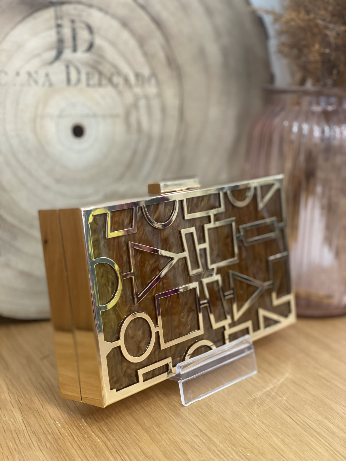 Bolso nacarado con montura en color dorado, en tonos color marrón.