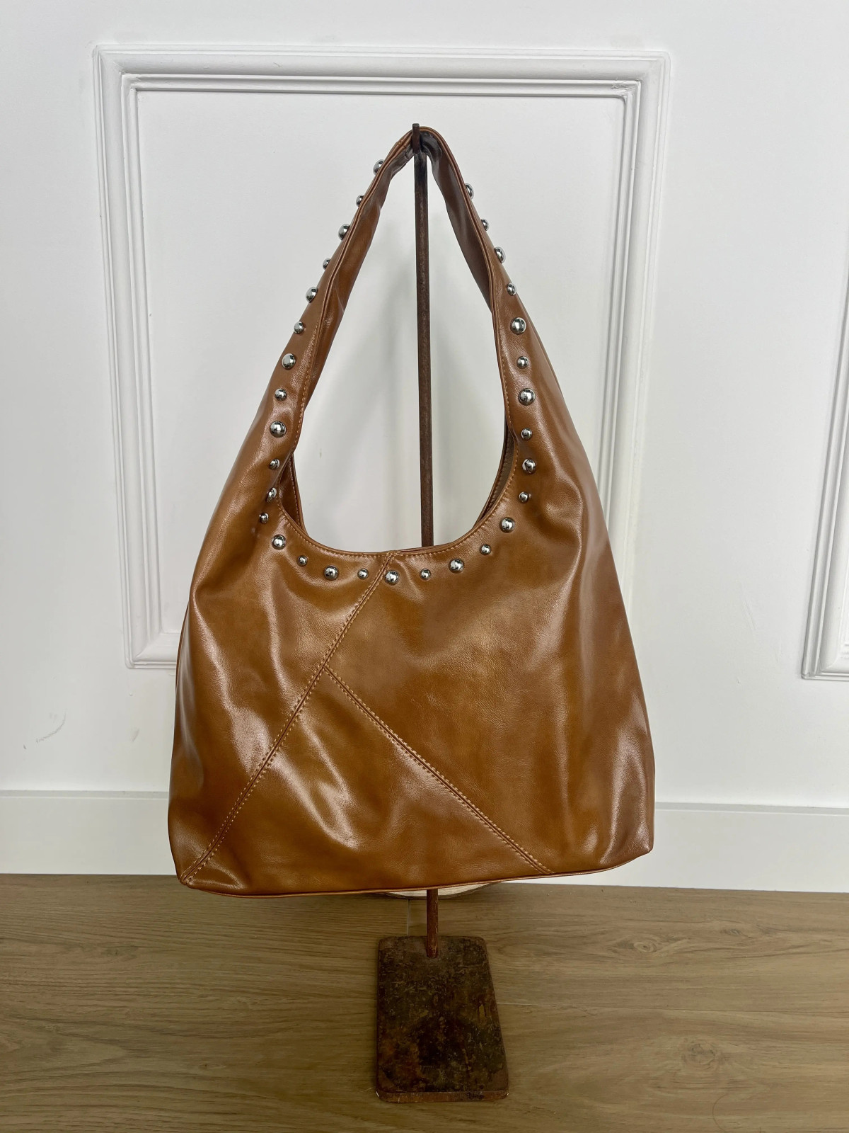 Bolso grande de polipiel adornado con tachuelas plata.