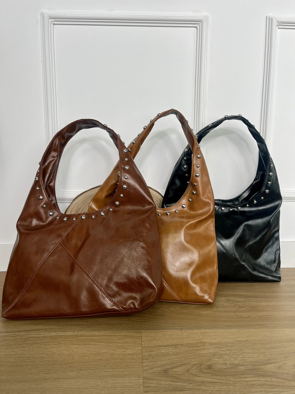 Bolso grande de polipiel adornado con tachuelas plata.