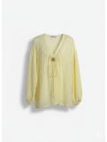 Blusa oversize en tono amarillo pastel.