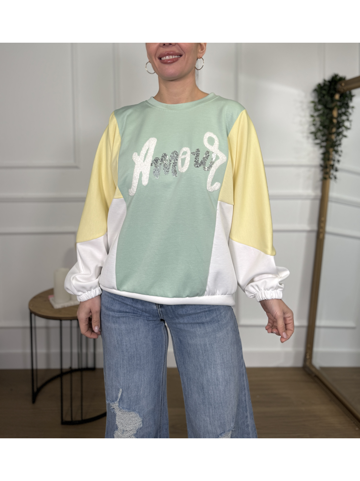 Sudadera combinada en tonos verde agua, amarillo pastel y blanco.