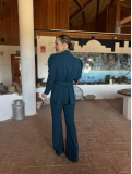 Traje de chaqueta con cinturón y pantalón acampanado.