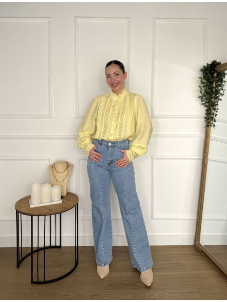 Pantalón vaquero en tono azul claro con detalles de tachuelas.