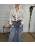 Camisa blanca con bordado floral en la parte frontal.