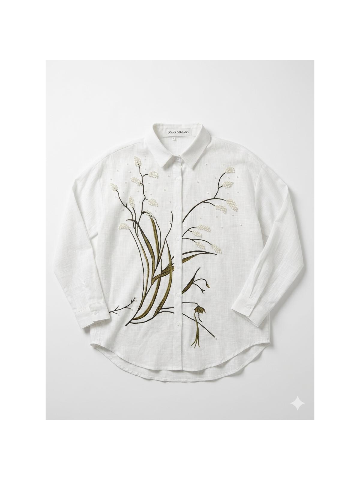 Camisa blanca con bordado floral en la parte frontal.