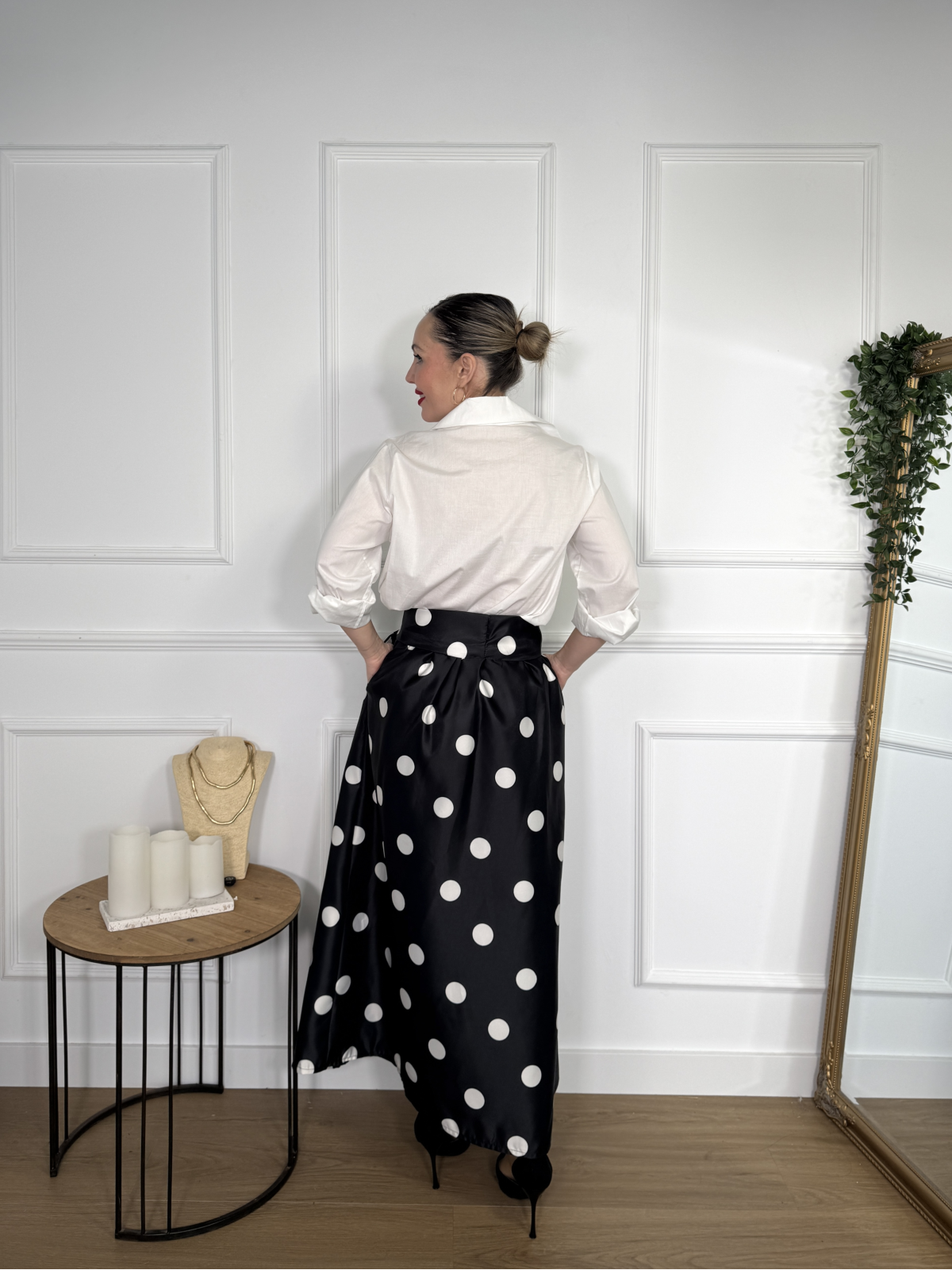 Falda midi en color negro con estampado de lunares blancos.