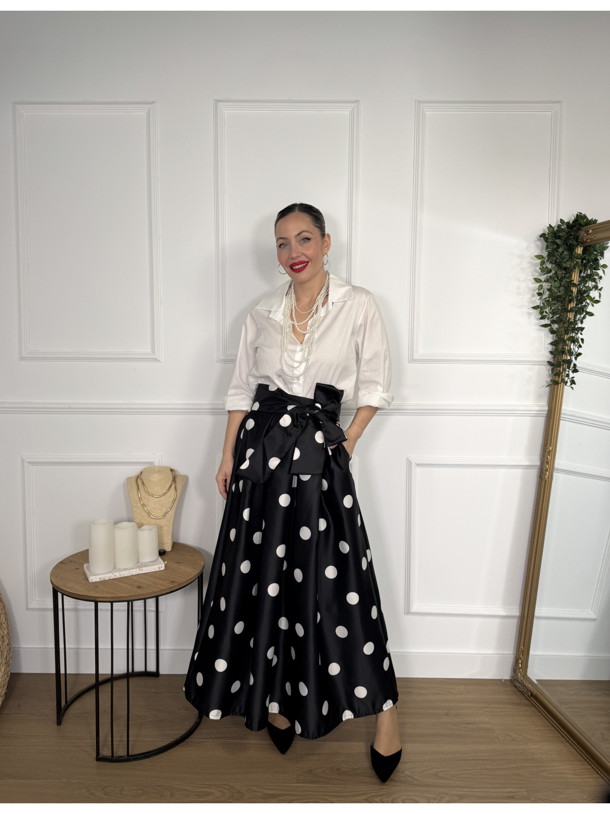 Falda midi en color negro con estampado de lunares blancos.