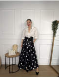 Falda midi en color negro con estampado de lunares blancos.