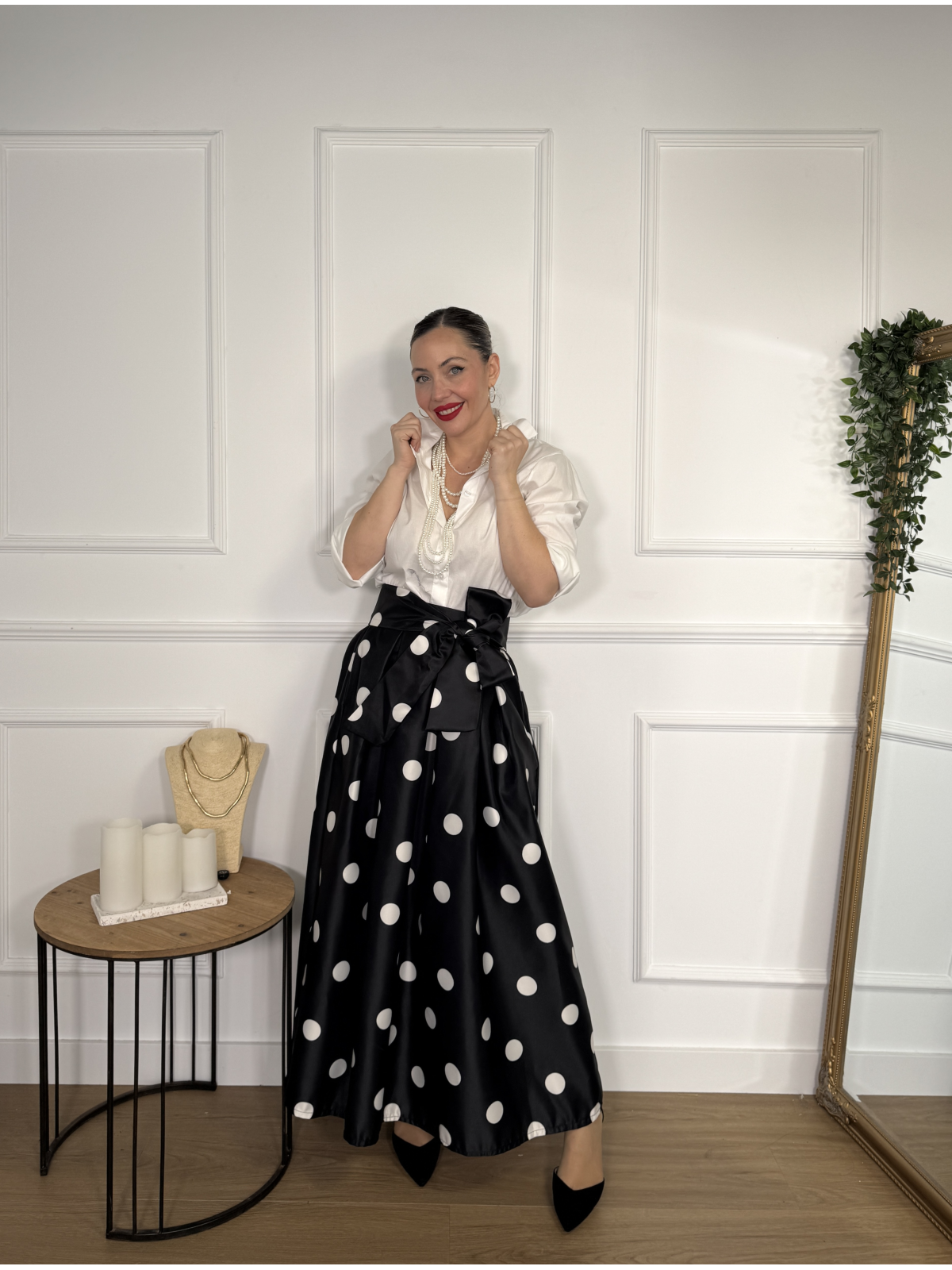 Falda midi en color negro con estampado de lunares blancos.