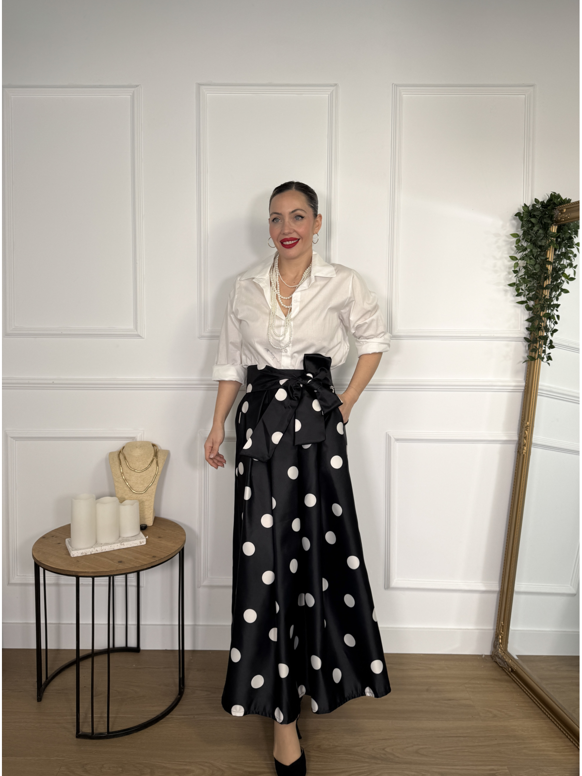 Falda midi en color negro con estampado de lunares blancos.