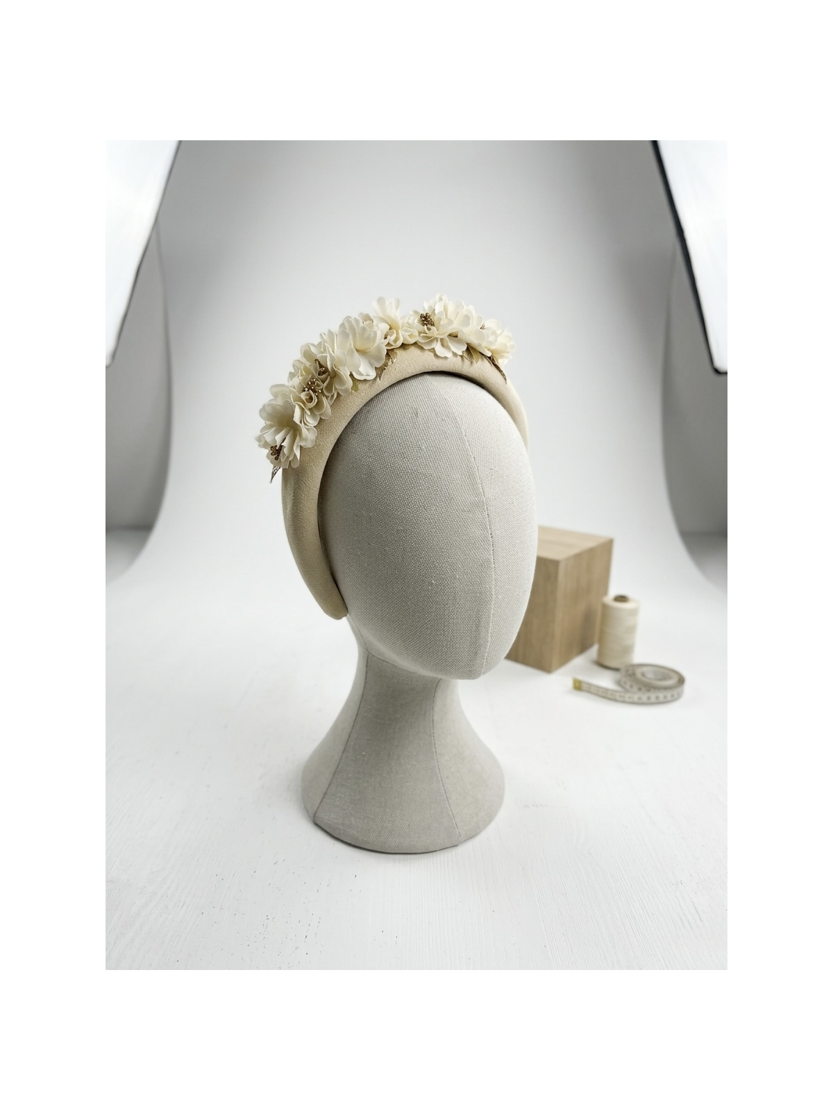 Diadema acolchada en tono marfil, decorada con delicadas flores.