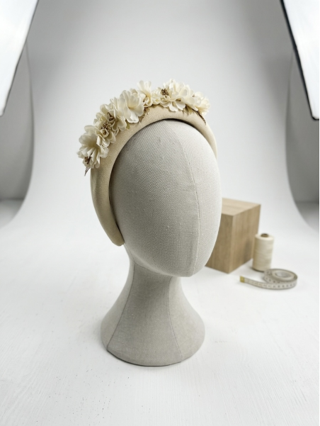 Diadema acolchada en tono marfil, decorada con delicadas flores.