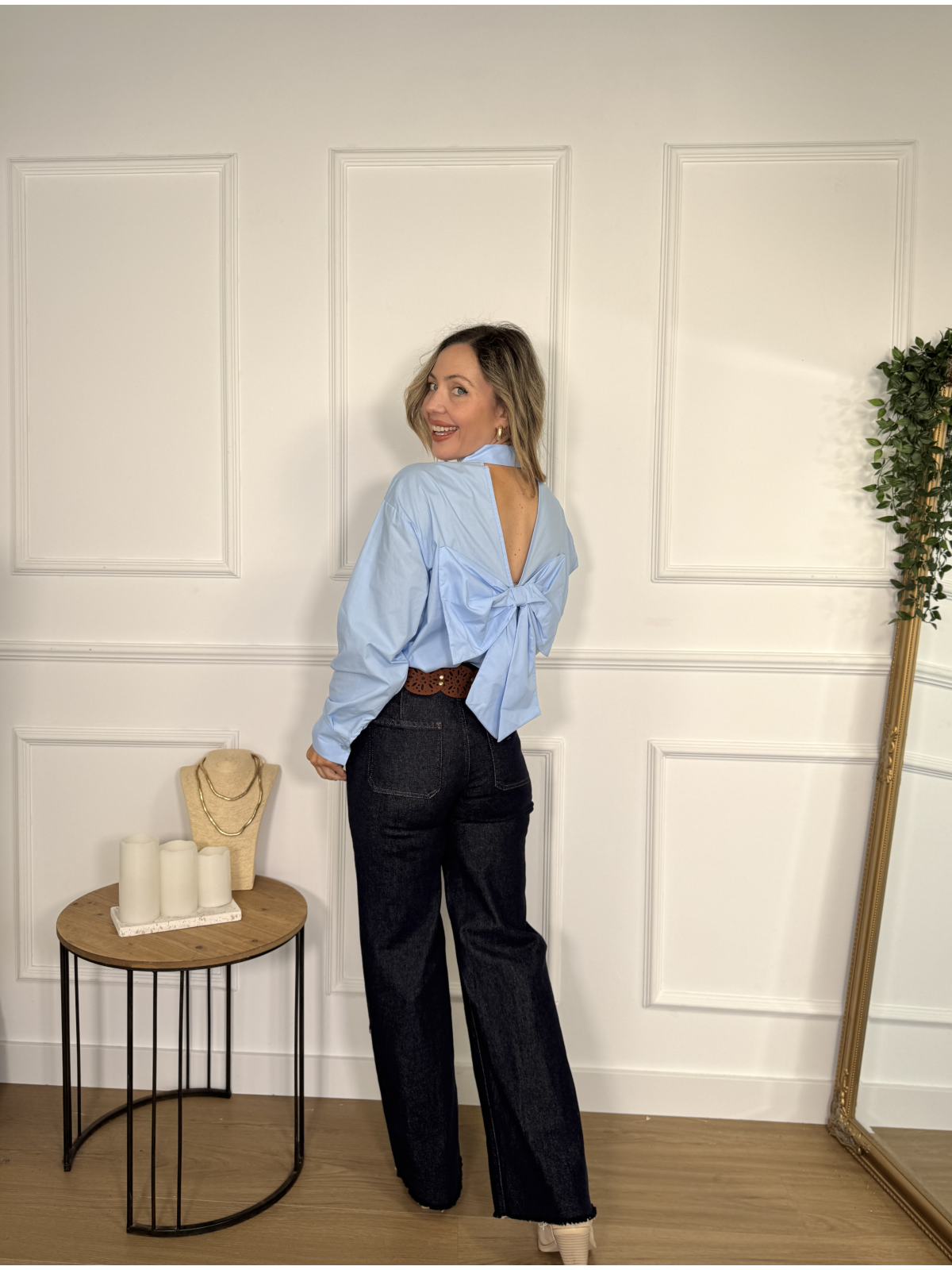 Camisa celeste con adorno de lazada en espalda.