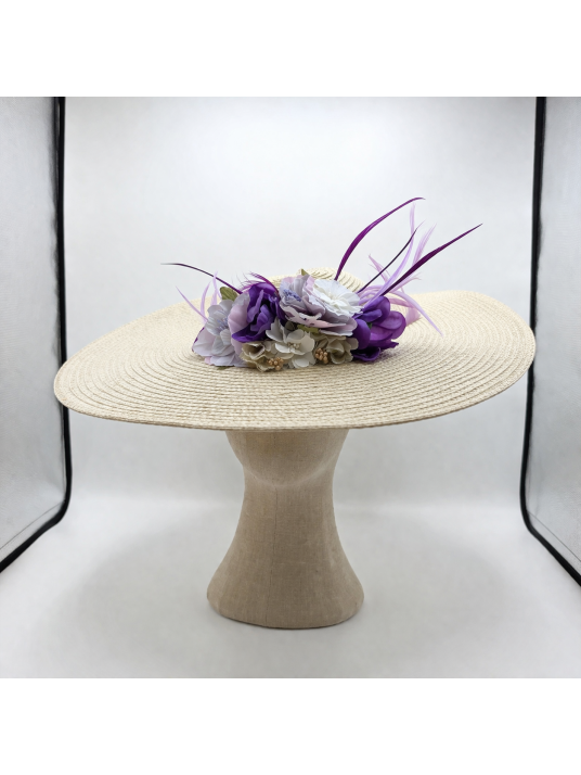 Pamela con base natural, adornada por flores y plumas en tonos malvas.