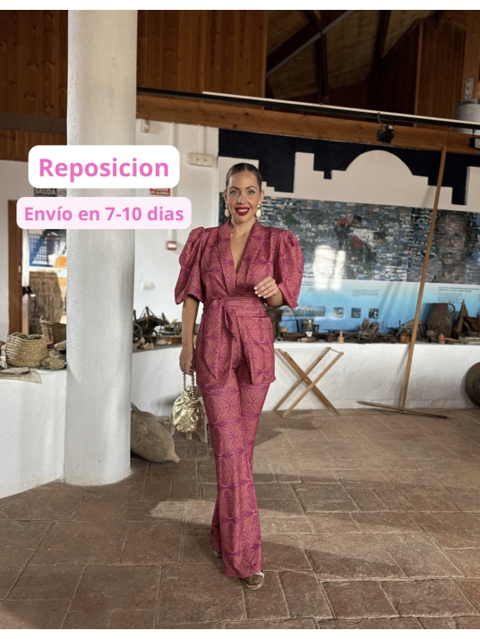 Traje de chaqueta con cinturón y pantalón acampanado.